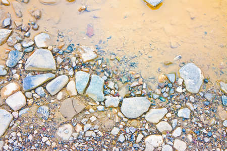 Puddle on rocky ground - background imageの写真素材