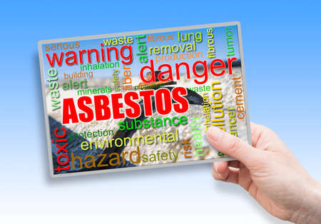 A female hand holding an card with asbestos themeの写真素材