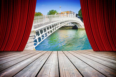 Open theater red curtains against the most famous bridge in Dublin called "Half penny bridge" (Ireland) - concept imageの写真素材