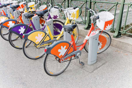 Rental of colorful bicycles parked on a street in Wien