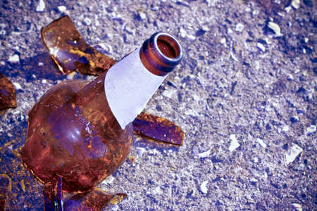 Shattered beer bottle resting on the ground - alcoholism concept - Image with copy spaceの写真素材
