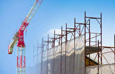 Italian construction site - concept mage with metal scaffolding and tower crane