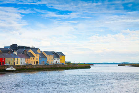 Irish coastal landscape with the typical colored fishermen's houses with sloping roofs (Galway -...