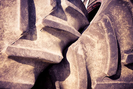 Pair of tires of a big tractor dismantled and left in a Italian country road - toned imageの写真素材