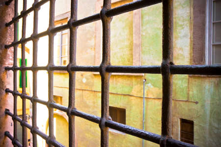 Rusty metal grate against a facade of an italian building 