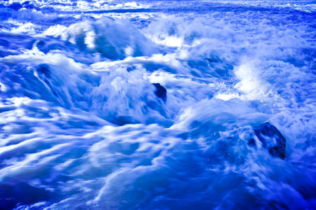 Rushing waters of a swollen river during the rainy season - toned imageの写真素材