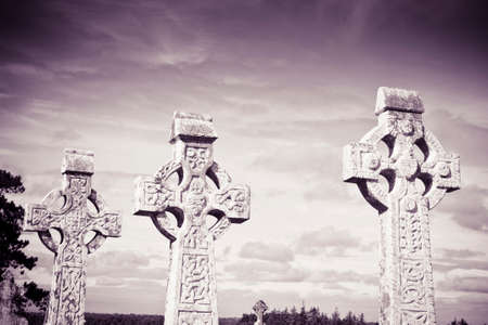 Celtic carved stone cross against a sky background - toned image の写真素材