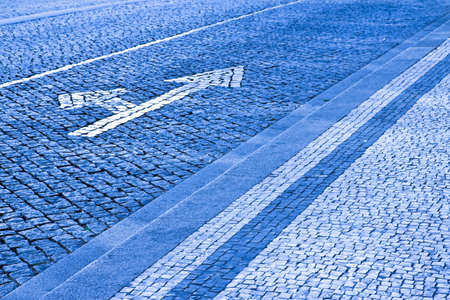 White arrow on stone road - concept image - toned image