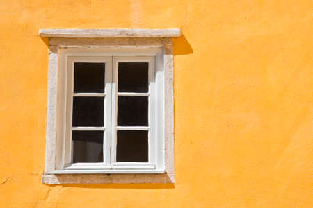 Typical portuguese window against a colored plaster wallの写真素材