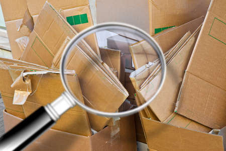 Stacks of paper and cardboard ready to be recycled - Concept image seen through a magnifying glass