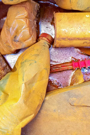 Illegal dumping in the nature. Plastic bottles and metal cans abandoned in a pondの写真素材