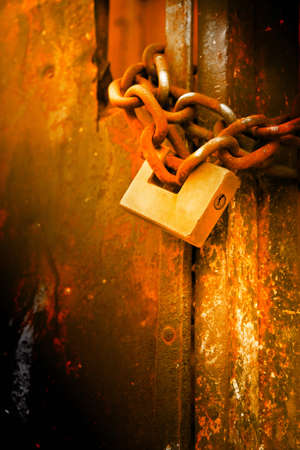 Rusty metal gate closed with padlock - concept image