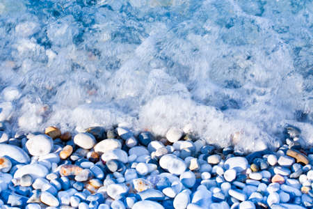Rounded white stones under fresh transparent waterの写真素材