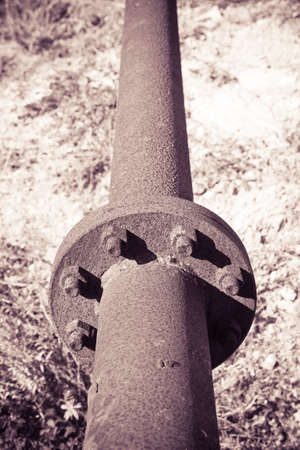 Detail of an old rusty pipeline with flange and bolts -toned imageの写真素材