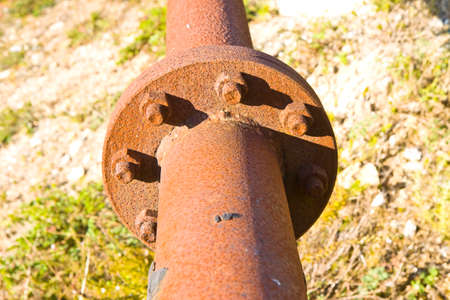 Old rusty pipeline with flange and bolts