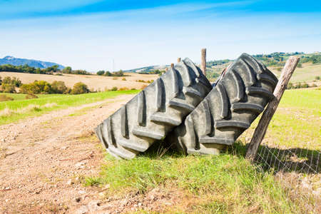 Pair of tires of a big tractor dismantled and left in a Italian country roadの写真素材