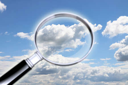Air pollution research. Concept image whit magnifying glass against a cloudy sky -の写真素材