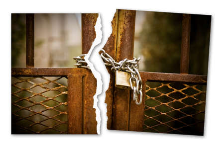 Ripped photo of a rusty metal gate closed with padlock - Freedom concept imageの写真素材