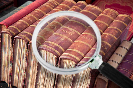 Old books in the flea market - every visible brand has been removed - Concept image seen through a magnifying glass.の写真素材