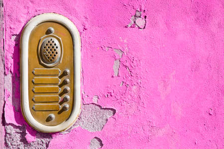 Old stone and brass bell system against a colored plaster wall - image with copy space.の写真素材