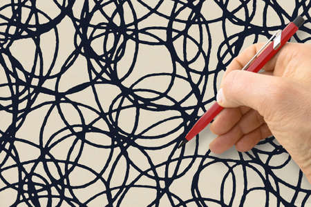 Hand writing a black doodle background on beige paper - concept image.