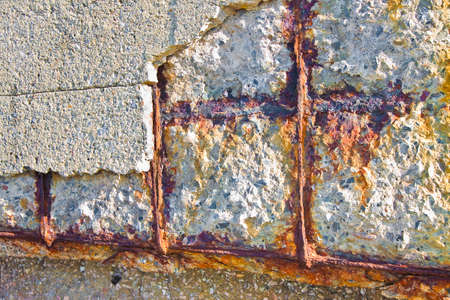 Reinforced concrete with damaged and rusty metallic reinforcementの写真素材