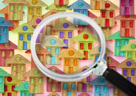 Searching new home - concept image with colorful houses seen through the magnifying glass.の写真素材
