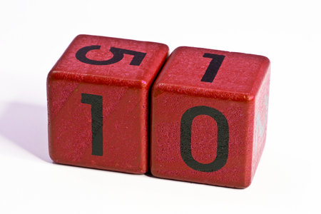 Number ten written on a red wooden cube of a calendar date.
