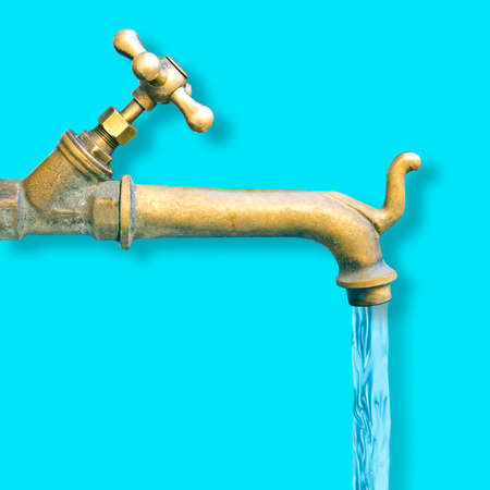 Detail of a vintage water brass faucet isolated on solid color background - image with copy space.
