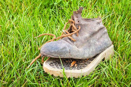 Old broken boot abandoned in a grass carpetの写真素材