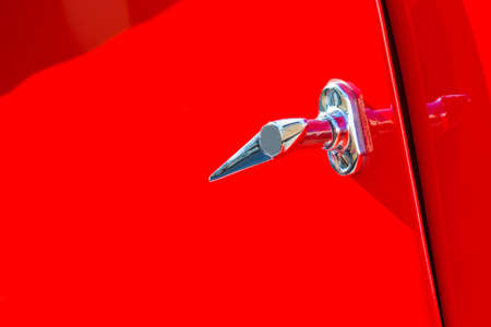 Chromed handle detail on red background of a vintage sports car - image with copy spaceの写真素材