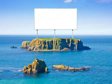 Blank advertising billboard on a small rocky island in the middle of the ocean - concept image with copy spaceの写真素材