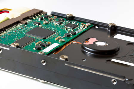 Hard drive with electronic componensts - concept image seen through a magnifying glass.