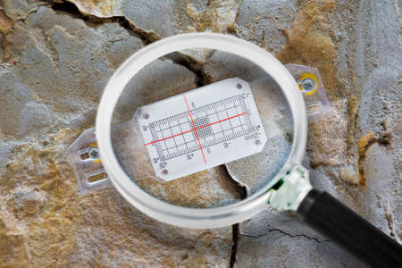 Deep crack in a damaged old stone wall cause due to subsidence of foundations structural failures...