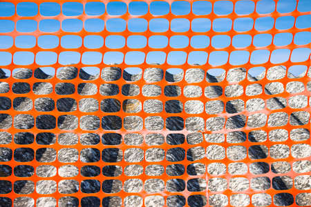 Construction site with safety plastic orange grid and old aged dangerous asbestos roof - concept image.の写真素材