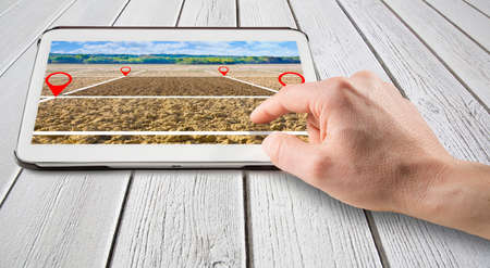 Land plot management - real estate concept with a vacant land available for building construction with a digital deviceの写真素材