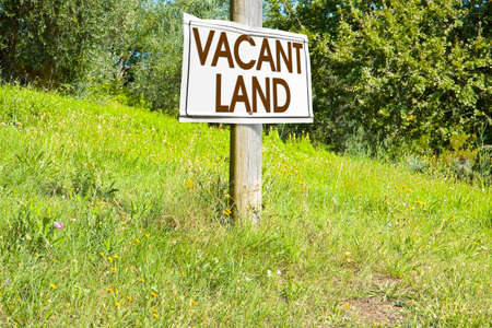 Building lot on hilly land - Land plot management - Real estate concept with a vacant land on a green field available for building construction and housing subdivision in a residential areaの写真素材