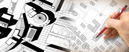 Planning a new city - Engineer-architect drawing with a pencil a sketch of a new modern imaginary town - concept image.の写真素材