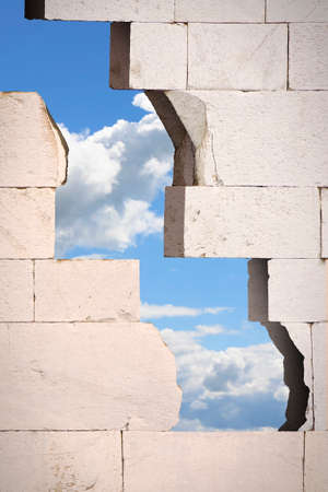 Through a cracked stone wall you see the sky - concept imageの写真素材