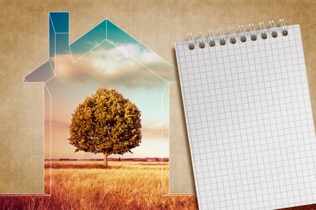 Little home silhouette, rural scene with a lone tree in a field, block notes with copy spaceの写真素材