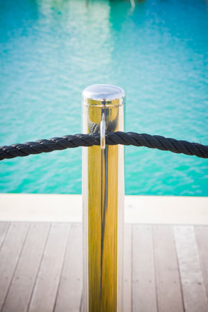 Metal pole with black rope isolated on blue backgrpund