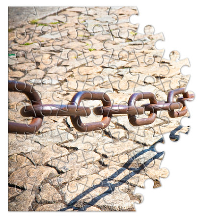 Old rusty metal chain - freedom concept image in jigsaw puzzle shapeの写真素材