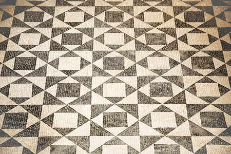 Ancient Italian Roman mosaic floor with triangular shapes composed of small white and black stone...