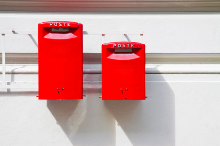 Old italian public red mailbox against a plaster wall - image with copy spaceの写真素材