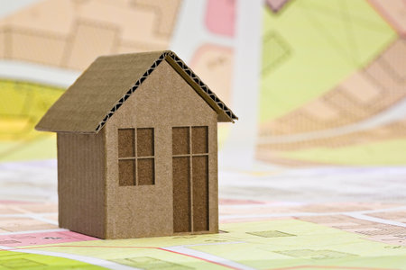 Imaginary cadastral map and General Urban Plan with buildings, land parcel and indications of urban destinations - real estate property concept with cardboard houseの写真素材