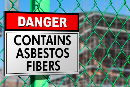 Dangerous presence of asbestos fibers in a construction site with metallic protection net against the intrusion of unauthorized persons and warning signboardの写真素材
