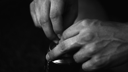 Hands opening a beverage can