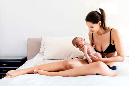 Mother and her newborn baby on the bedの写真素材