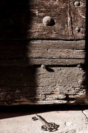 Historical key near a wooden doorの写真素材
