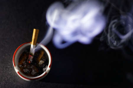 Ashtray and cigarette on a dark backgroundの写真素材
